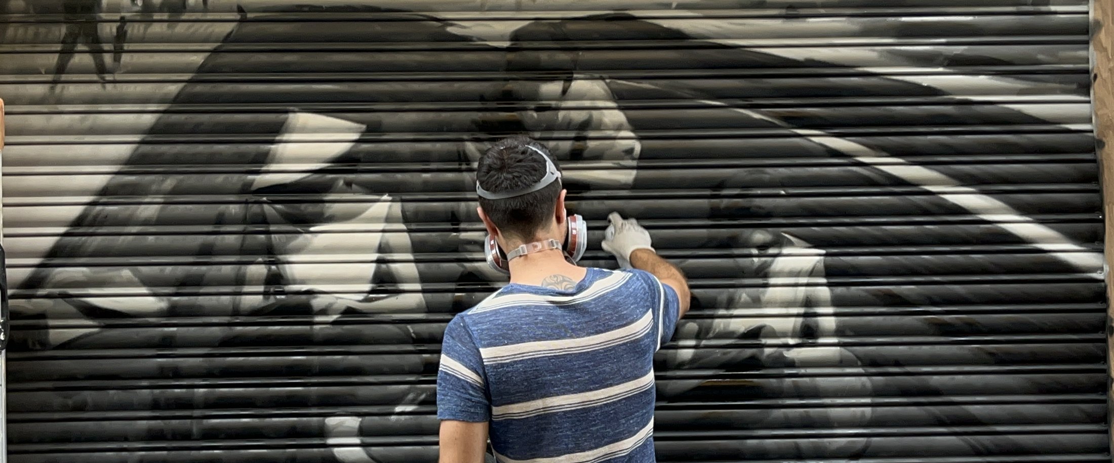 Pau Marinello pintant un mural al carrer